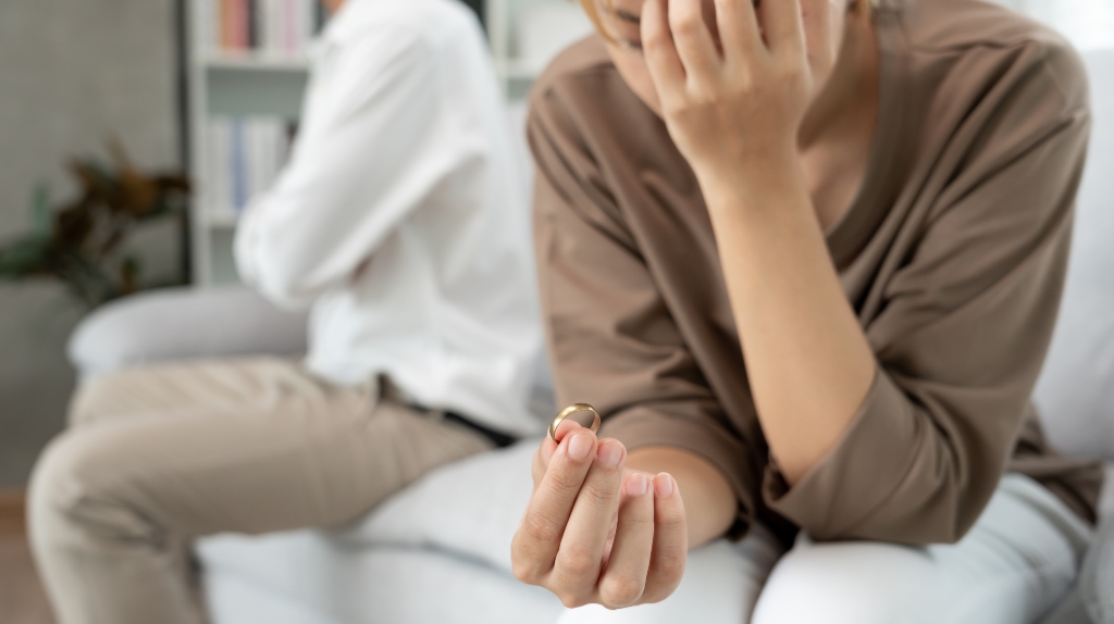 sad woman holding a ring in her hands making a decision about divorce