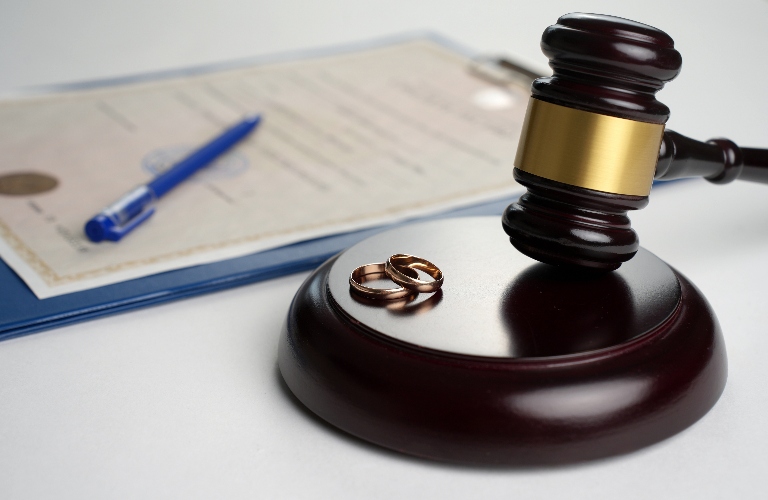 judge's gavel and wedding rings