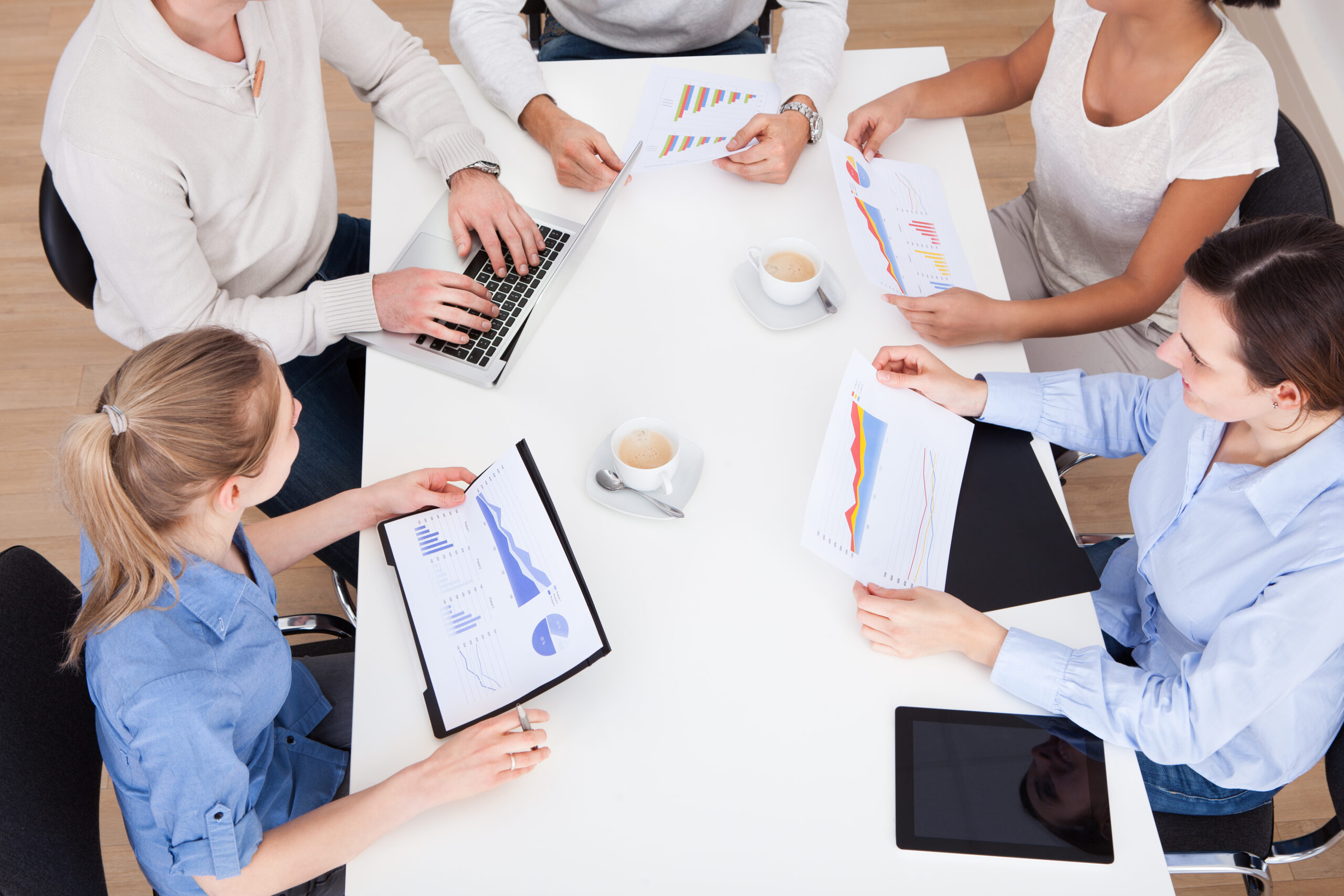 Group,Of,Businesspeople,Discussing,On,Graph,In,Meeting