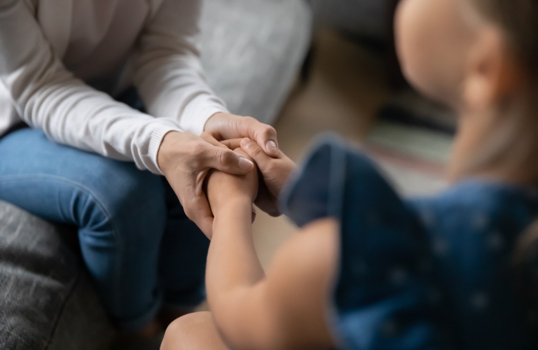 mother holds small daughter hands