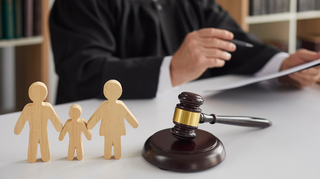 wooden figurines of family with child and judge's gavel