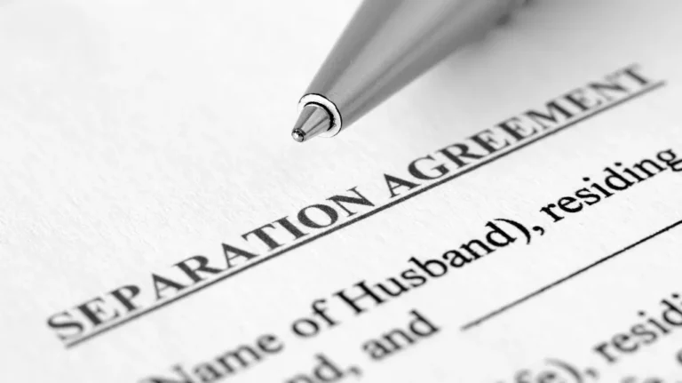 Close-up of a separation agreement document with a silver pen tip positioned near the title.