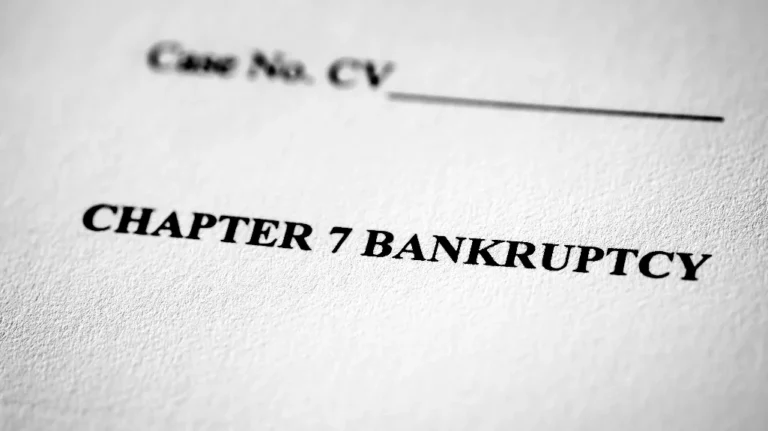 Close-up of a document with the bold heading "CHAPTER 7 BANKRUPTCY" printed on white textured paper.